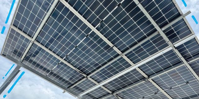 Rooftop solar modules seen from below against a clear sky